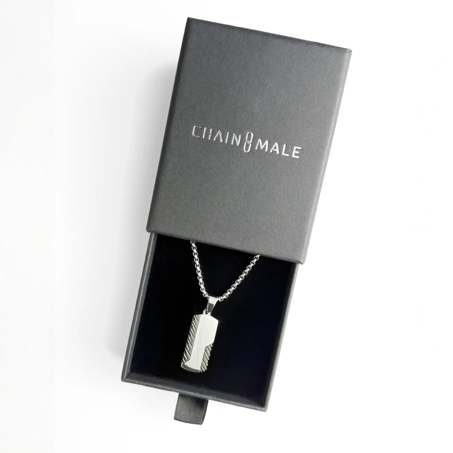 Silver stainless steel dog tag pendant necklace with black edges in a black Chain Male jewellery box on a white background
