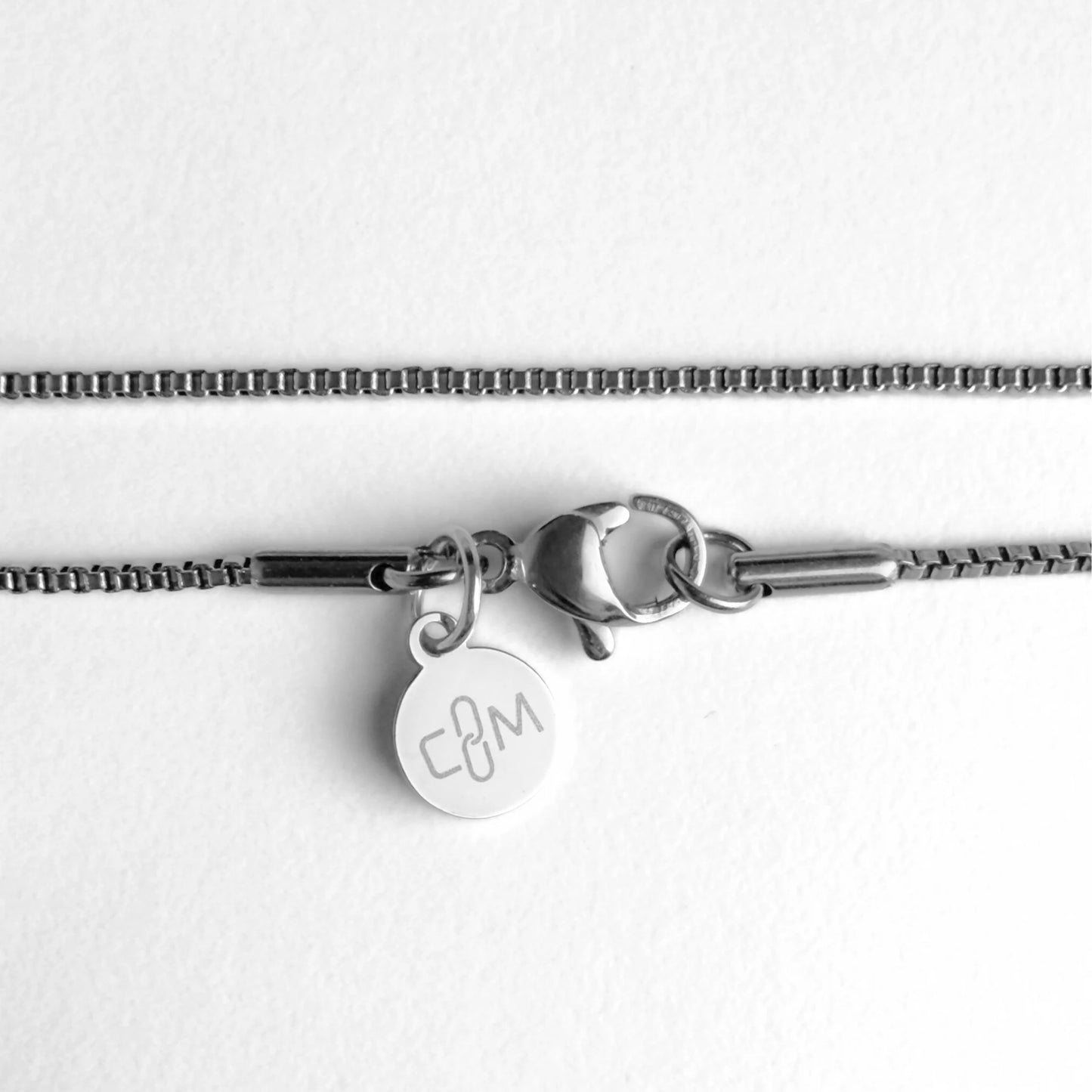 Chain Male silver 1.2mm box chain necklace flat lay with CM charm, fine stainless steel men's Everyday collection