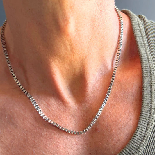 Chain Male silver 3mm box chain necklace close-up worn with singlet, square link stainless steel men's jewellery