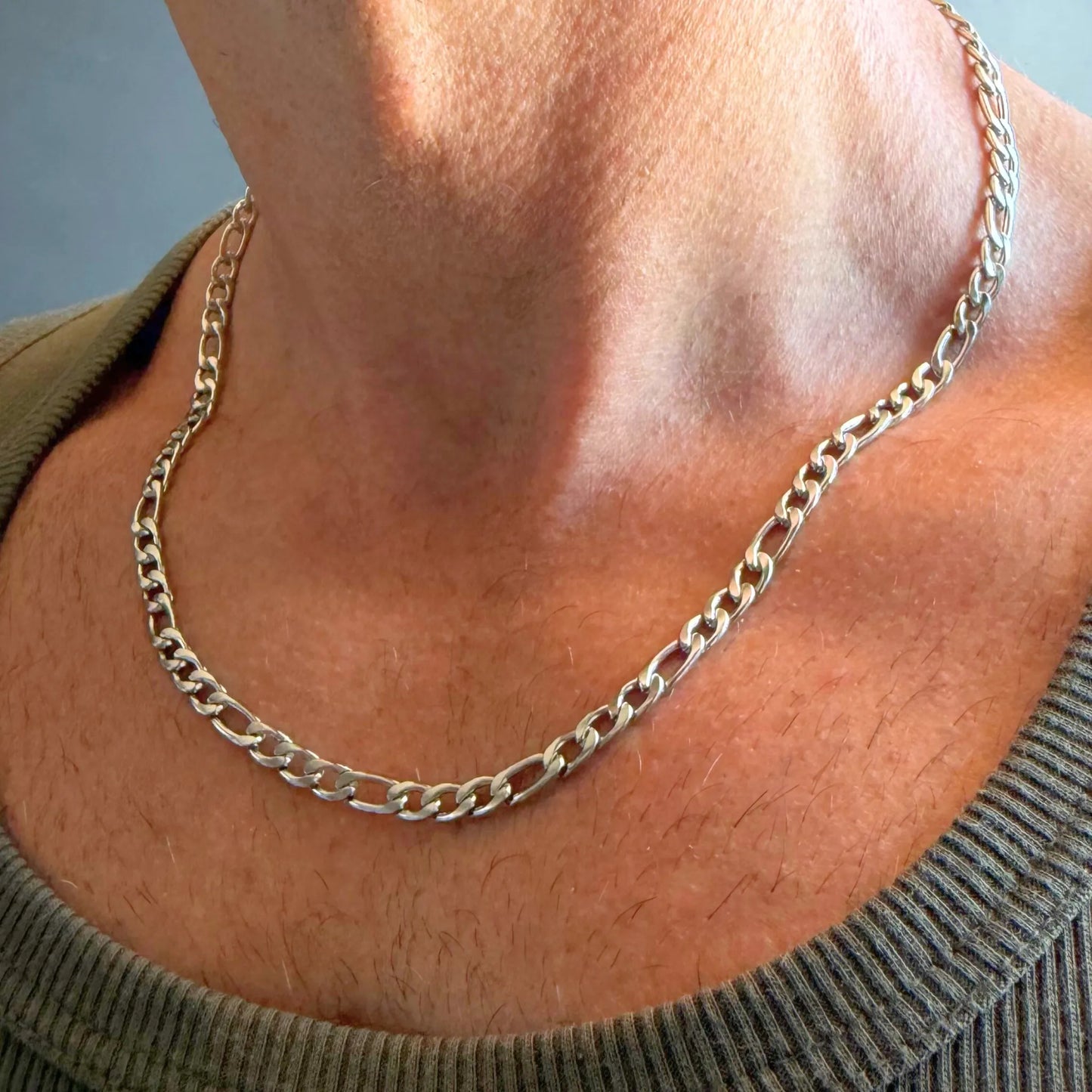 Chain Male silver 5mm Figaro chain necklace close-up worn with singlet, stainless steel alternating link men's jewellery