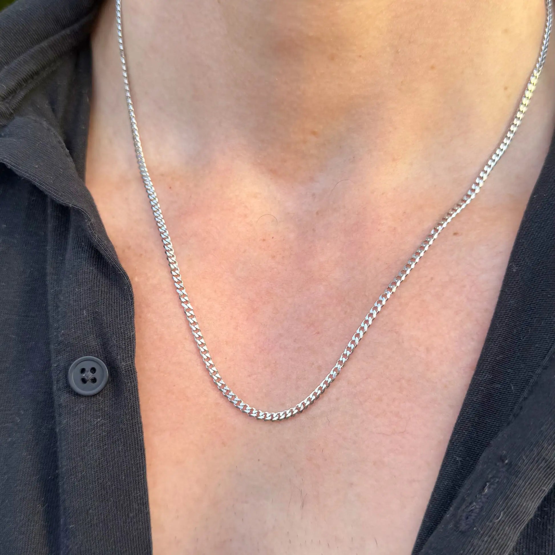 Chain Male silver 3mm curb chain necklace close-up, slim everyday men's stainless steel jewellery