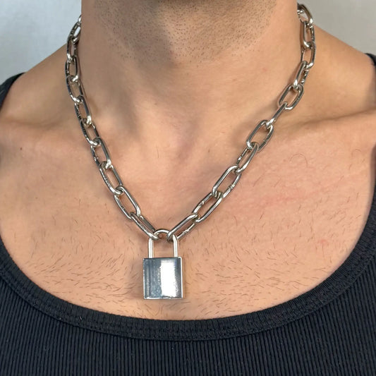 Close-up of a light duty stainless steel padlock chain necklace worn on a chest in a black singlet