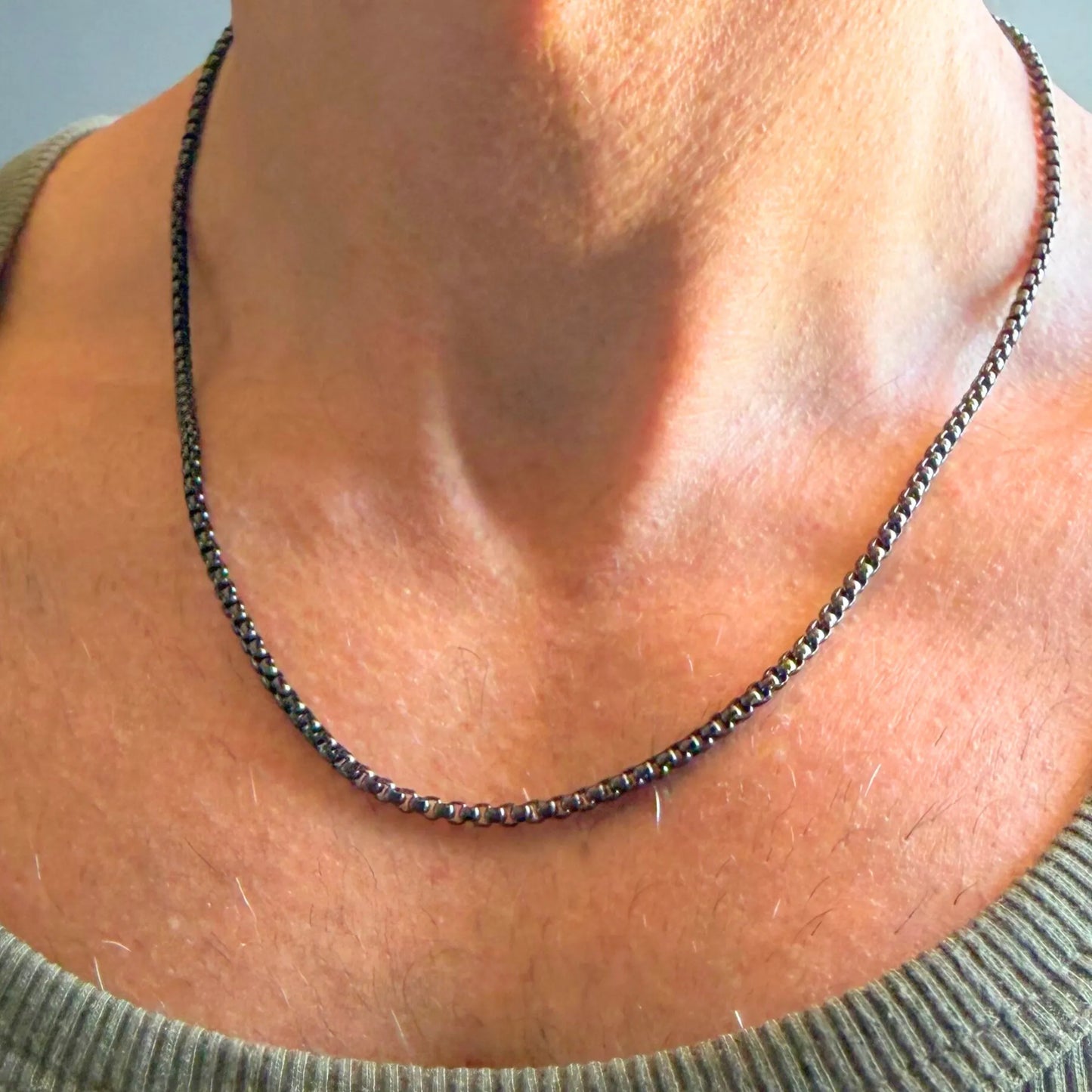 Chain Male black rolo chain necklace close-up worn with singlet, black plated rounded link stainless steel men's jewellery
