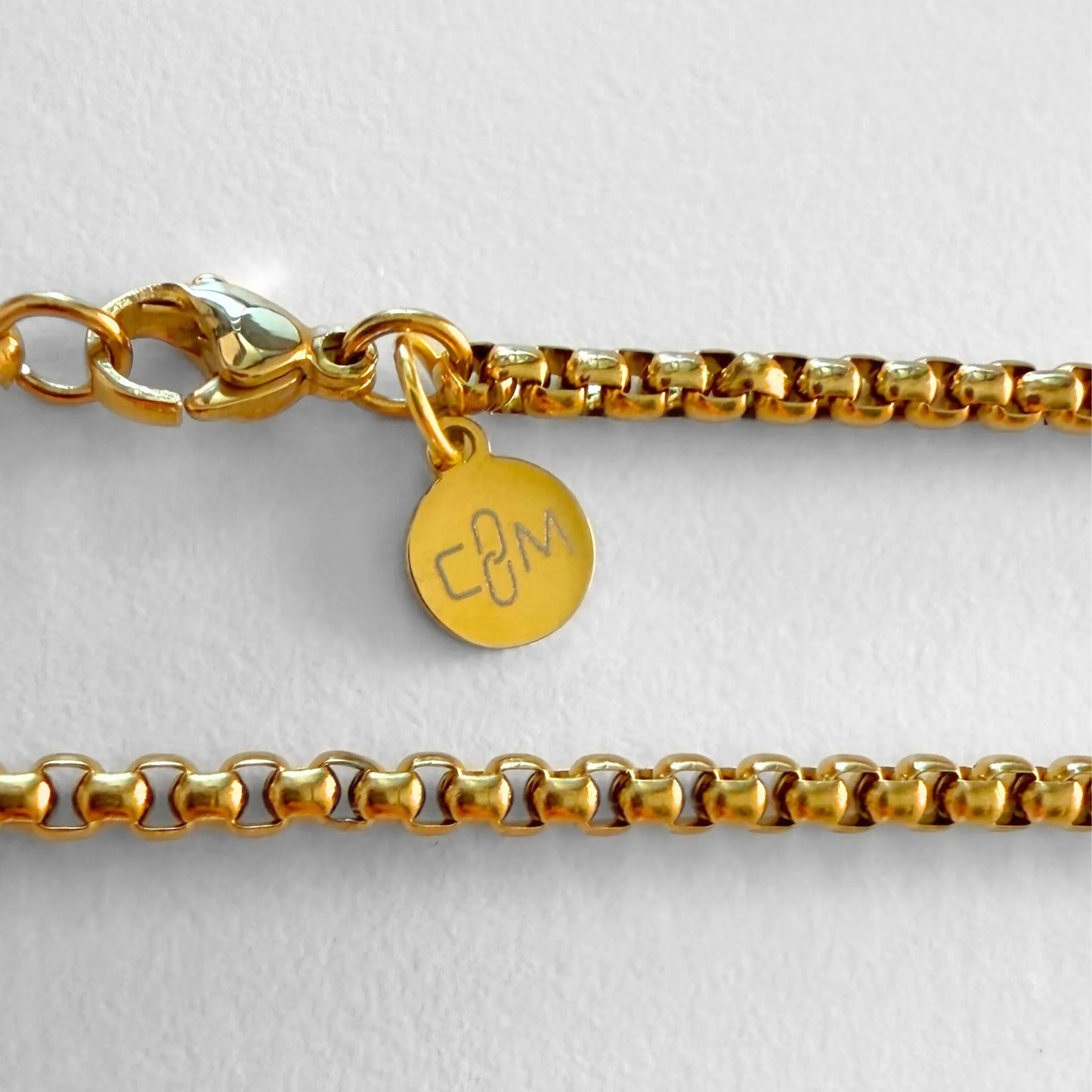 Chain Male gold rolo chain necklace flat lay with CM charm, 18ct gold plated men's Everyday collection