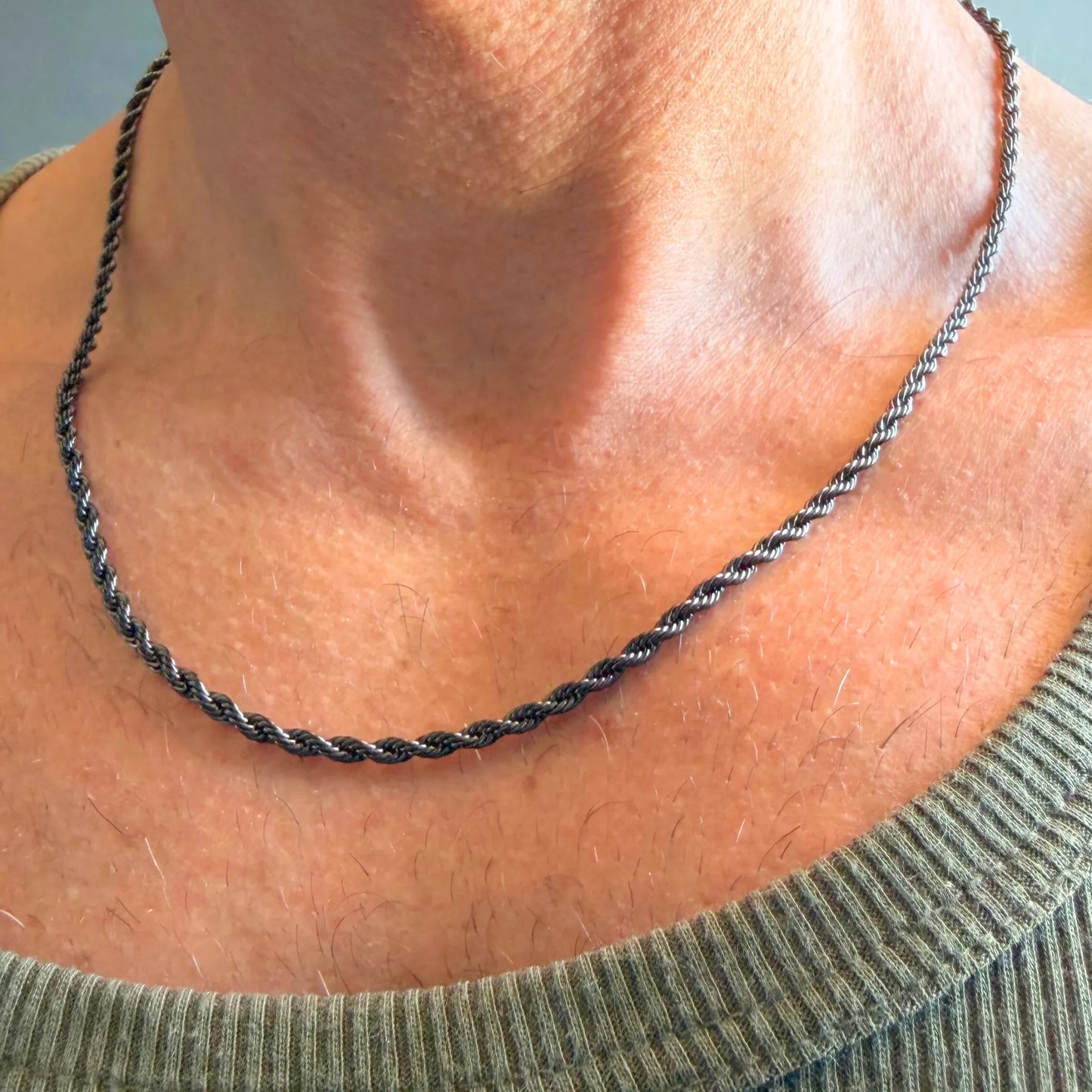 Chain Male black rope chain necklace close-up worn with singlet, black plated twisted stainless steel men's jewellery