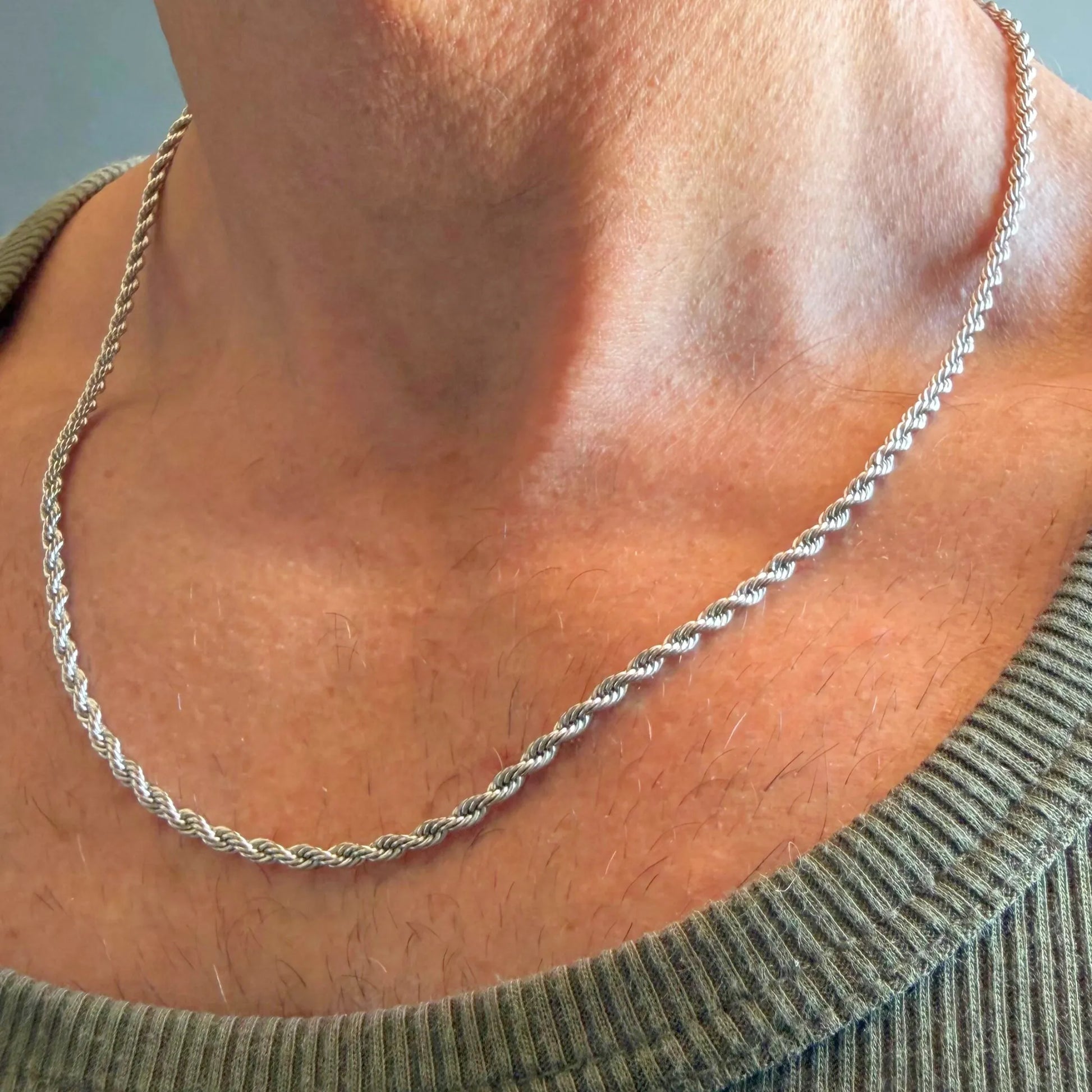 Chain Male silver rope chain necklace close-up worn with singlet, twisted stainless steel men's jewellery