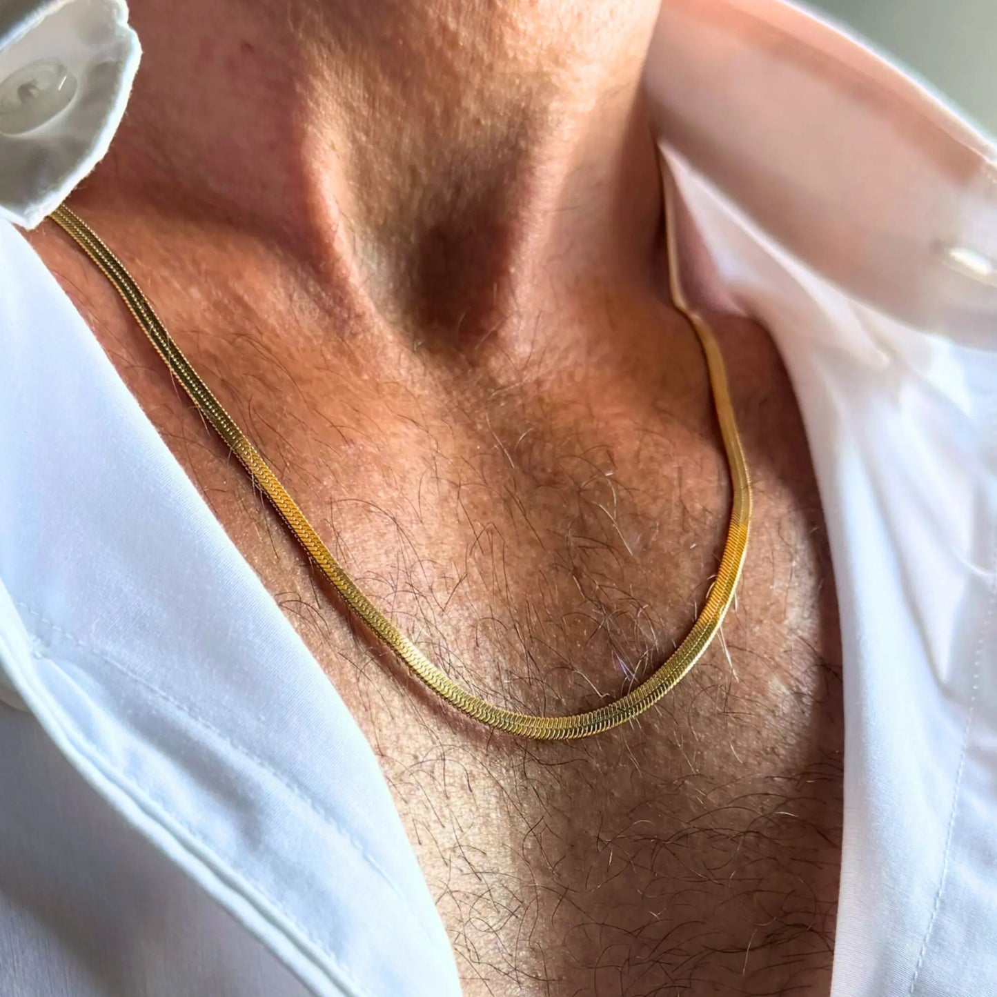 Chain Male gold 3mm snake chain necklace close-up worn with open shirt, 18ct gold plated men's jewellery