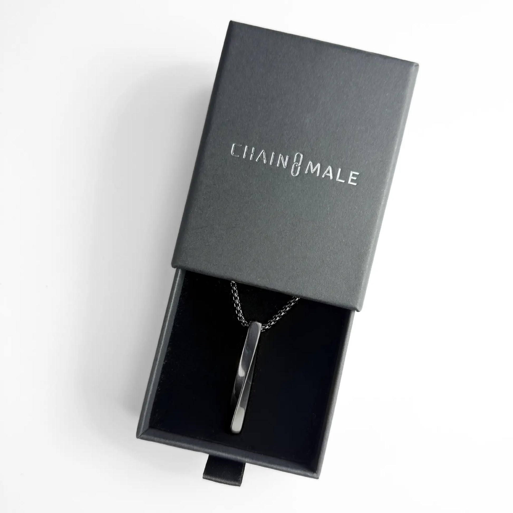 Black bar pendant necklace in a black Chain Male jewellery box on a white background